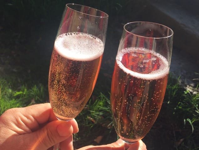 růžový sekt ve sklenici přípitek